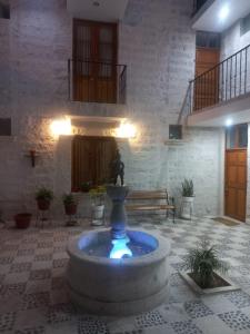 a fountain in the middle of a courtyard with a bench at Quinta Alpaca in Arequipa