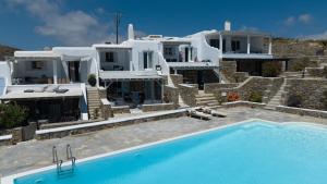 a large house with a swimming pool in front of it at VILLA 11.7 in Elia Beach