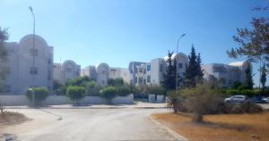 a parking lot in front of a large building at Appartement très coquet dans résidence in Hammamet
