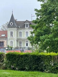 a large white house with a grey roof at La Bonne Maison 3 in Troyes