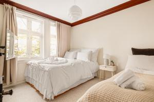 1 dormitorio blanco con 2 camas y ventana en Dinbnb Homes I 200m to Bryggen I Make Memories with Friends and Family! en Bergen