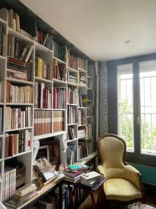 a library with a desk and chairs and books at La Bonne Maison 3 in Troyes