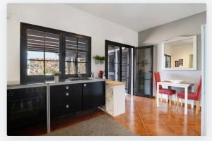 a kitchen with a sink and a dining room with a table at Villa Petronila Tías, LANZAROTE in Conil