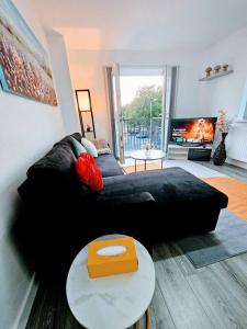 un soggiorno con divano nero e tavolo di Swanky 1-Bedroom Apt in Walsall a Bescot