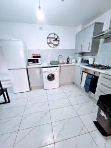 a white kitchen with a washing machine and a washer at Swanky 1-Bedroom Apt in Walsall in Bescot