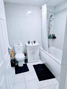 a bathroom with a toilet and a tub and a sink at Swanky 1-Bedroom Apt in Walsall in Bescot