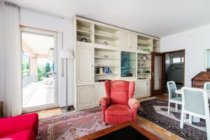 a living room with a red chair and a window at Miravalle Lakeview by Quokka 360 - large windows and magical views in Massagno