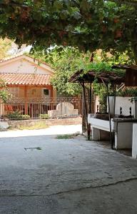 un pavillon avec une table et un banc devant une maison dans l'établissement Niki Apartments Sea View Attic, à Platamonas