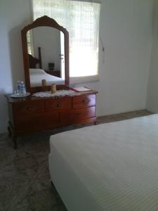 a bedroom with a dresser with a mirror and a bed at Polish Princess Guest House in Port Antonio