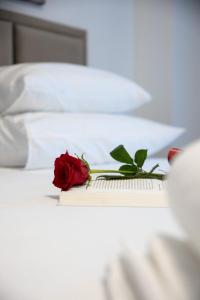 a red rose sitting on top of a book on a bed at Apartments M&A in Kaštela