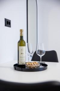 Una botella de vino y dos copas en una mesa. en Apartments M&A, en Kaštela