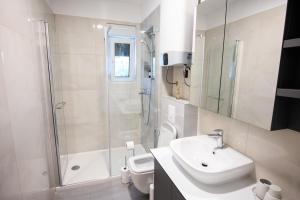 a bathroom with a sink and a shower and a toilet at Apartments M&A in Kaštela