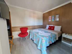 a hotel room with a bed and a red chair at Porto De Galinhas Pousada Raízes Do Porto in Porto De Galinhas +54 photos