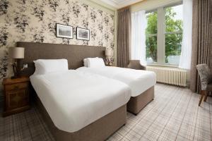um quarto de hotel com uma cama grande e uma janela em The Waterhead Inn- The Inn Collection Group em Ambleside