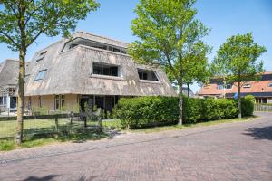 an old house with a thatched roof on a street at Waddenresidentie Ameland Zilt, een ruim 4-persoons appartement in Buren