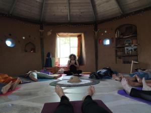 un grupo de personas sentadas en una habitación haciendo yoga en ביתהבוצ - מקום טבעי למפגשים, en Talmei Yosef