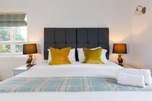 a bedroom with a large bed with yellow pillows at 4 Canon Lane in Chichester