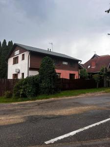 una casa al lado de una carretera al lado de una valla en Parks Guest House en Sigulda