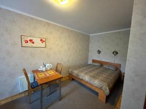 Dormitorio pequeño con cama y mesa en Parks Guest House en Sigulda