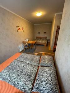 a room with two beds and a table and a dining room at Parks Guest House in Sigulda