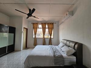 una camera con letto e ventilatore a soffitto di Sapphire Residence a Jenjarum
