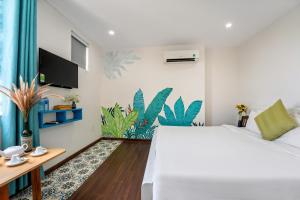 a bedroom with a large white bed and a desk at La Casa Tra Que in Hoi An