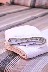 a stack of white towels sitting on a bed at Barigui Park Hotel in Curitiba