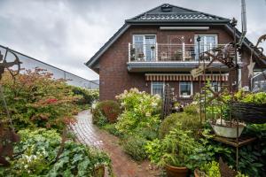 a brick house with a garden in front of it at Die Kleine Oase 3 im Wohnhaus in Stuhr