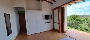 a room with a tv on a wall with a window at Finca Buena Vista in Guatapé