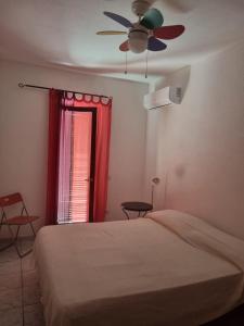 um quarto com uma cama e uma ventoinha de tecto em Casa vista mare golfo di Budoni em Budoni