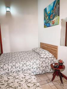 a small bedroom with a bed and a table at Pousada Estância Mineira in Guapé