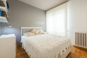 Dormitorio blanco con cama y cartel en la pared en Via Augusta, en Barcelona
