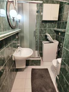 a bathroom with a sink and a toilet and a mirror at Korczaka Skyline in Elblag