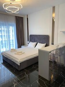 a bedroom with a bed and chairs and a chandelier at Vista del Mar in Mamaia