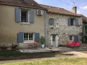 una casa con sillas rojas y una mesa frente a ella en Clos PIMI en Monbazillac