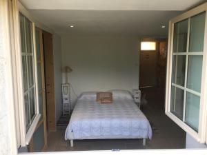 een slaapkamer met een bed in een kamer met ramen bij Clos PIMI in Monbazillac