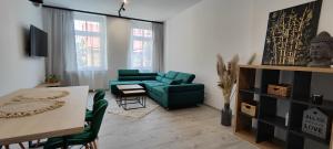 uma sala de estar com um sofá verde e uma mesa em CITY VIEW Saperów II - przy centrum klimatyzacja em Świdnica