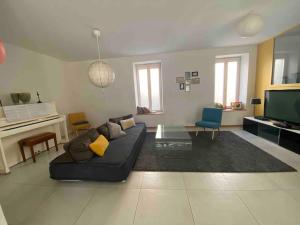 een woonkamer met een bank en een televisie bij La maison Familiale in Dijon