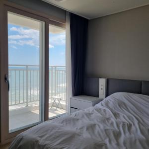 1 dormitorio con cama y vistas al océano en Yangyang Ocean Stay en Yangyang