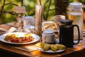 a wooden table with a plate of food on it at Inigtan Lio Bamboo Cottages in El Nido