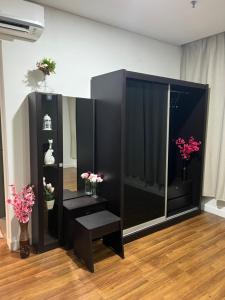 a black cabinet with flowers in a room at Summer Suite KLCC By Citybox in Kuala Lumpur