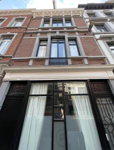 a tall brick building with many windows on it at St Catherine in Liège