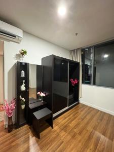 a living room with black furniture and wooden floors at Summer Suite KLCC By Citybox in Kuala Lumpur