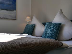 a bed with blue and white pillows on it at Privathotel Bremer in Bergisch Gladbach