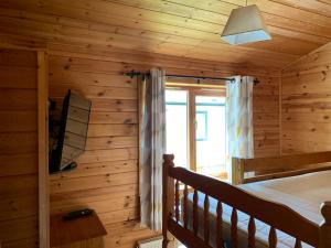 Dormitorio en cabaña de madera con cama y ventana en Immaculate 3-Bed Lodge in Hawick, en Hawick