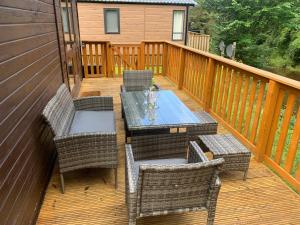 a patio with a table and chairs on a deck at Immaculate 3-Bed Lodge in Hawick in Hawick