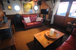 ein Wohnzimmer mit einem Sofa und einem Tisch mit einer Kerze in der Unterkunft Swept Away Inn in Port Alberni