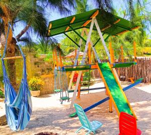 um parque infantil com baloiços coloridos e cadeiras em Flats Macapá Meu Amor 5 em Luís Correia