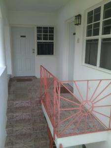 a staircase in a house with a red railing at Polish Princess Guest House in Port Antonio