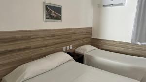 una camera con due letti, un lavandino e aermott di Hotel Casa Blanca Porto Seguro a Porto Seguro